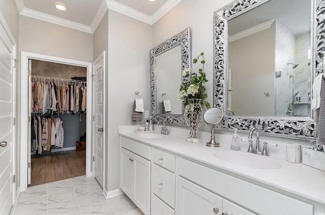 full bath with tiled shower, a spacious closet, a sink, and double vanity