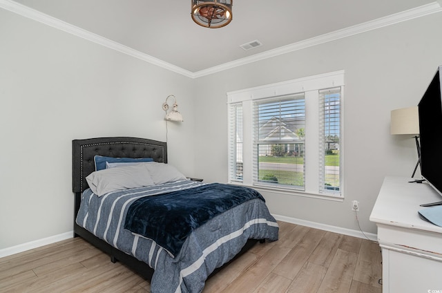 bedroom featuring baseboards, crown molding, visible vents, and light wood-style floors