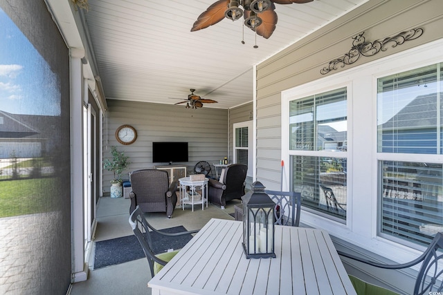 sunroom featuring outdoor dining area and ceiling fan