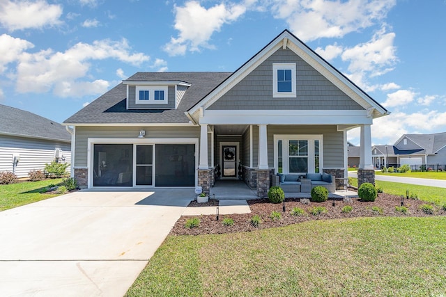 craftsman-style house featuring concrete driveway, stone siding, covered porch, and a front yard