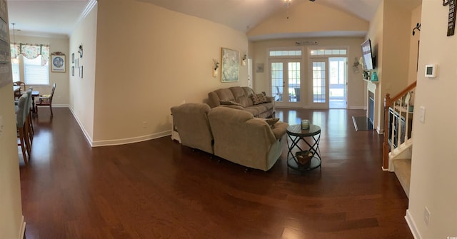 living room featuring dark wood-style flooring, baseboards, a ceiling fan, crown molding, and lofted ceiling
