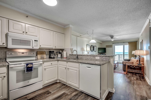 720 N Waccamaw Dr Unit 207, Garden City Beach, SC 29576 - kitchen with dark wood-type flooring, white appliances, a sink, and a peninsula