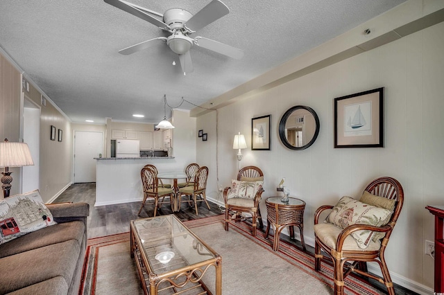 720 N Waccamaw Dr Unit 207, Garden City Beach, SC 29576 - living room featuring a ceiling fan, a textured ceiling, baseboards, and dark wood finished floors