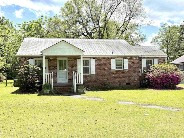 ranch-style home featuring crawl space, metal roof, a front lawn, and brick siding