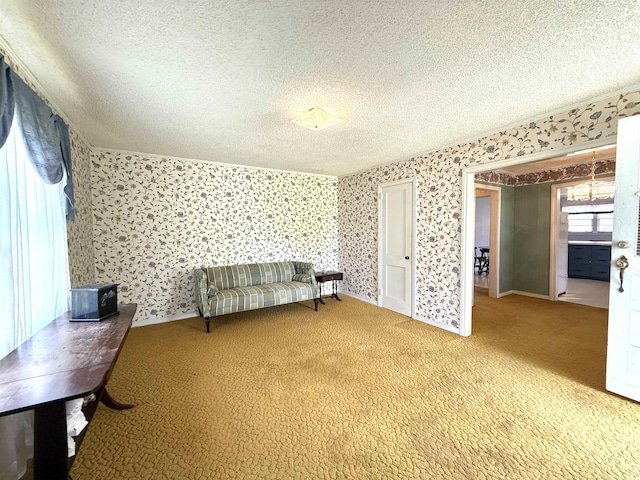 sitting room with carpet, a textured ceiling, and wallpapered walls