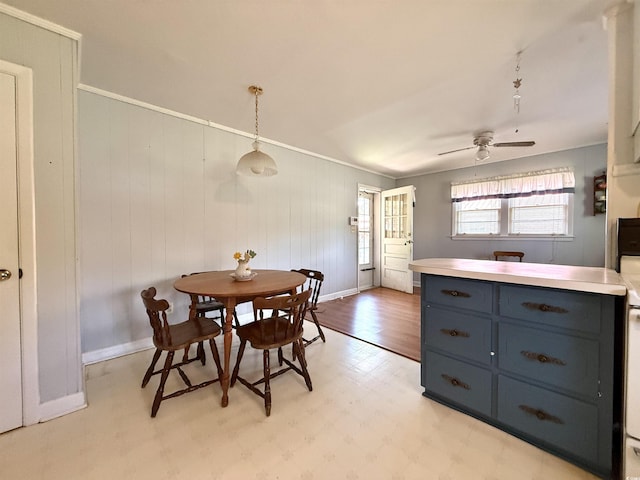 dining area featuring ornamental molding, baseboards, a ceiling fan, and light floors
