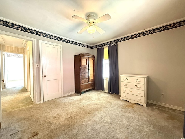 unfurnished bedroom featuring light carpet, attic access, and baseboards