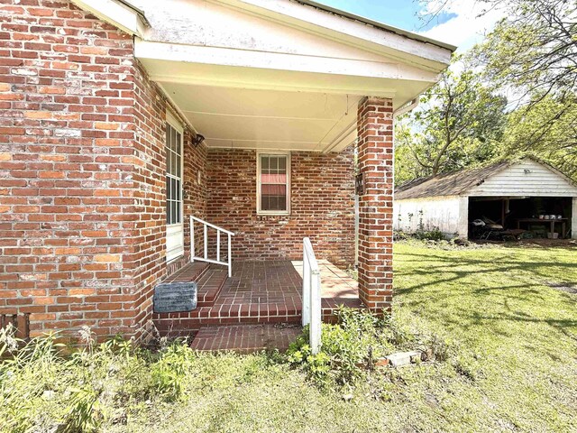 exterior space with brick siding and a yard