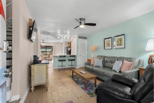 707 S 26th Ave S Unit L, North Myrtle Beach, SC 29582 - living room with a ceiling fan, light wood finished floors, a textured ceiling, and baseboards