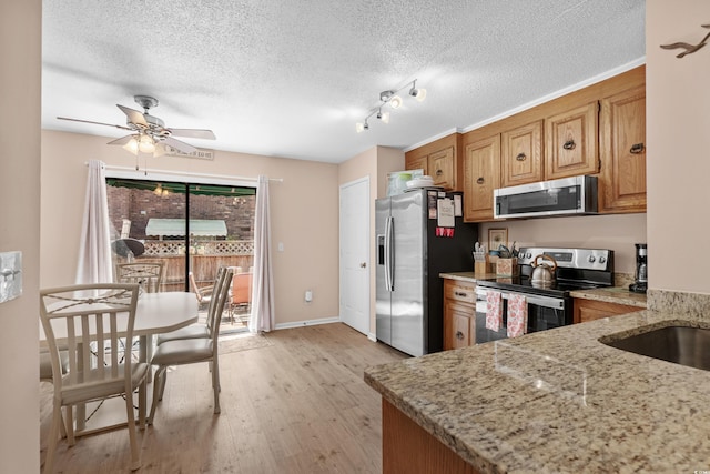 707 S 26th Ave S Unit L, North Myrtle Beach, SC 29582 - kitchen featuring stainless steel appliances, light wood finished floors, a ceiling fan, light stone counters, and a textured ceiling
