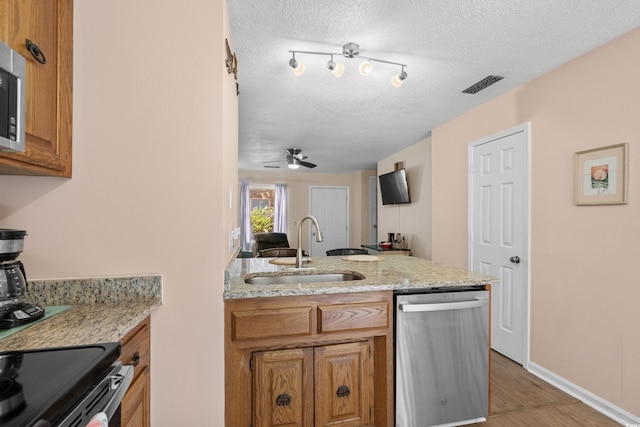 707 S 26th Ave S Unit L, North Myrtle Beach, SC 29582 - kitchen featuring dishwasher, a sink, a textured ceiling, brown cabinets, and light wood-type flooring