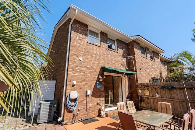 707 S 26th Ave S Unit L, North Myrtle Beach, SC 29582 - rear view of house with central air condition unit, brick siding, a patio, and outdoor dining space