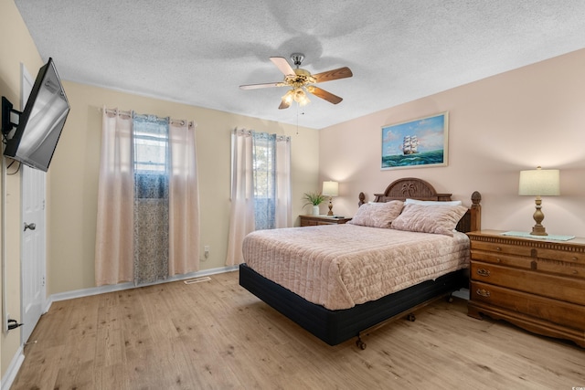 707 S 26th Ave S Unit L, North Myrtle Beach, SC 29582 - bedroom featuring light wood finished floors, a textured ceiling, ceiling fan, and baseboards