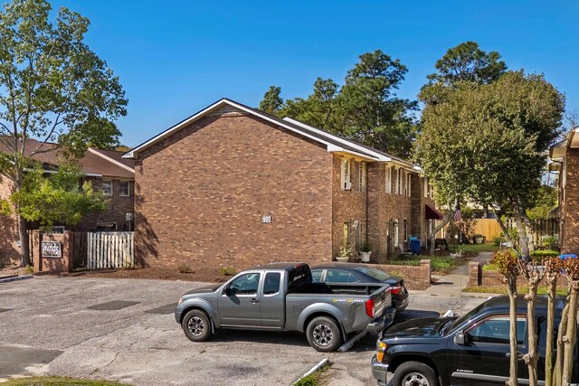 707 S 26th Ave S Unit L, North Myrtle Beach, SC 29582 - view of side of property featuring brick siding and uncovered parking