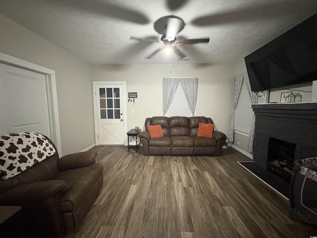 living area with wood finished floors, a textured ceiling, baseboards, and ceiling fan