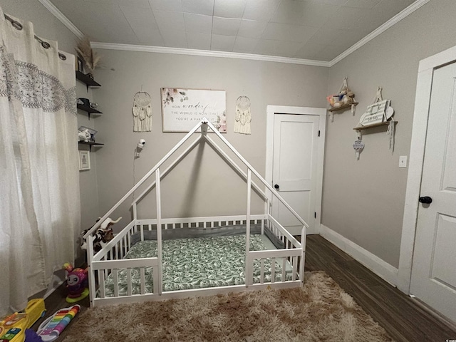 unfurnished bedroom with baseboards, wood finished floors, and ornamental molding