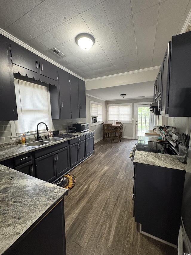 kitchen featuring visible vents, dark wood-style flooring, a sink, and crown molding