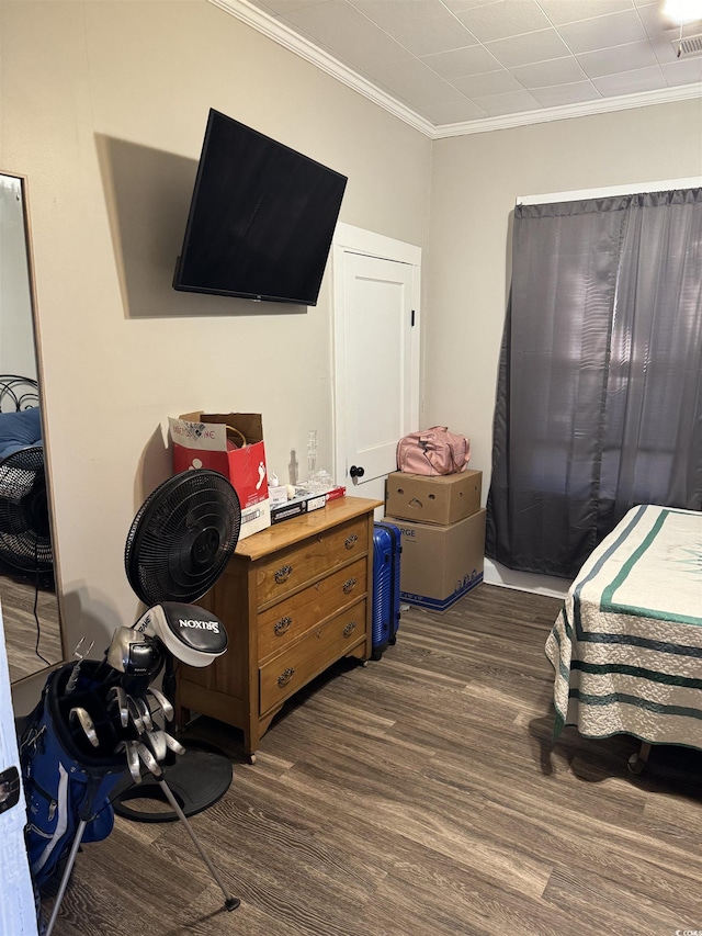 bedroom with dark wood finished floors, visible vents, and ornamental molding