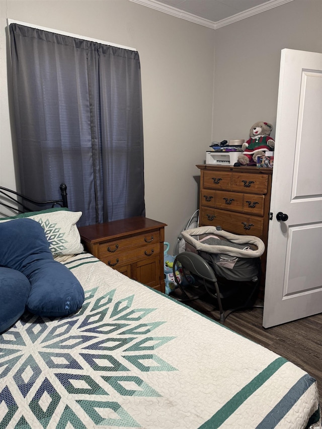 bedroom featuring ornamental molding and wood finished floors