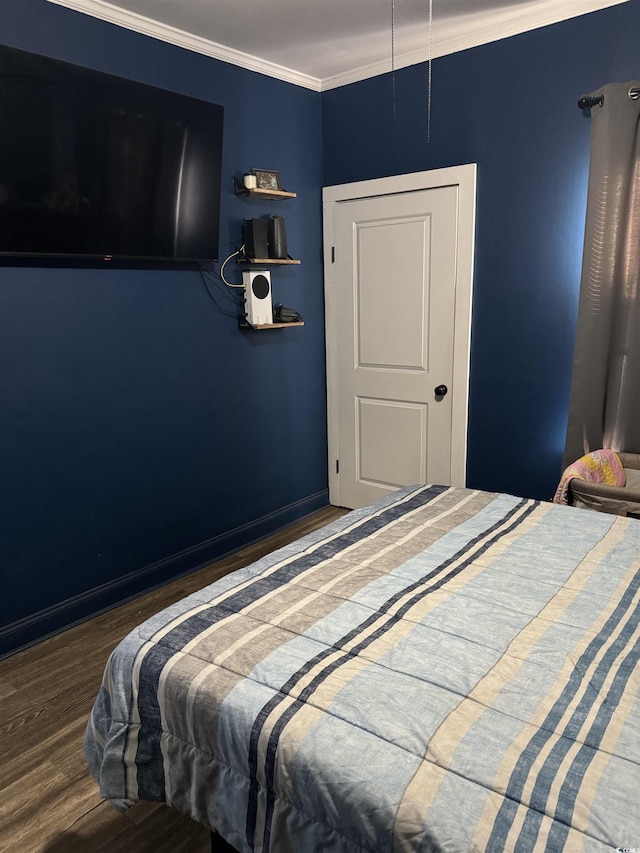 bedroom featuring baseboards, ornamental molding, and wood finished floors