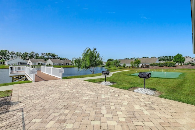 view of community featuring a water view, a yard, and a residential view