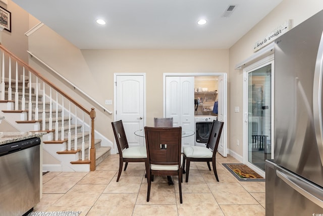 dining space featuring washer / clothes dryer, recessed lighting, light tile patterned floors, and stairs