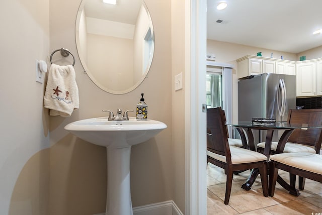 bathroom with tile patterned flooring, baseboards, visible vents, and tasteful backsplash