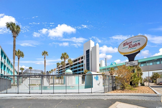 view of building exterior with fence and a community pool