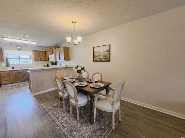 775 Plantation Dr Unit 87, Little River, SC 29566 - dining area featuring dark wood-style flooring, a chandelier, and a textured ceiling