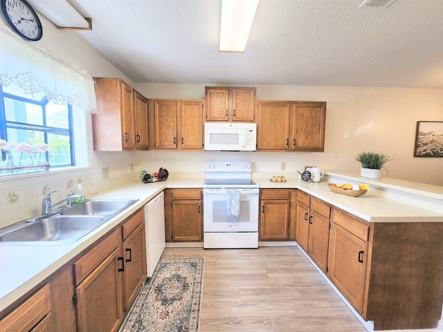775 Plantation Dr Unit 87, Little River, SC 29566 - kitchen featuring white appliances, a peninsula, light wood-style flooring, brown cabinets, and light countertops