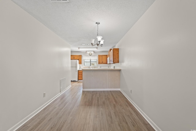 775 Plantation Dr Unit 87, Little River, SC 29566 - unfurnished living room with a chandelier, light wood-type flooring, and a textured ceiling