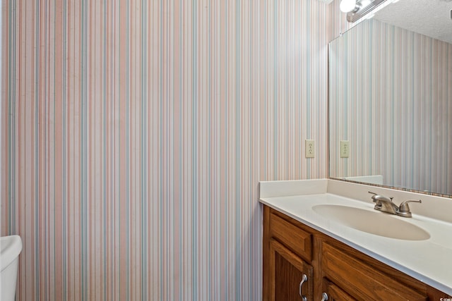 775 Plantation Dr Unit 87, Little River, SC 29566 - bathroom with wallpapered walls, vanity, and a textured ceiling