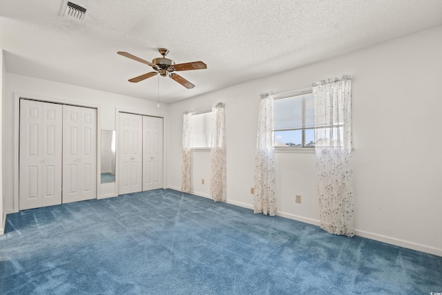 775 Plantation Dr Unit 87, Little River, SC 29566 - unfurnished bedroom featuring multiple closets, a textured ceiling, carpet flooring, and a ceiling fan