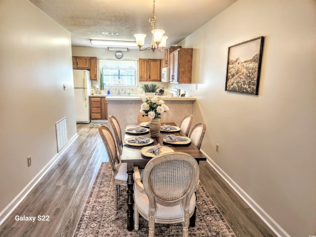 775 Plantation Dr Unit 87, Little River, SC 29566 - dining room featuring wood finished floors, a chandelier, and a textured ceiling