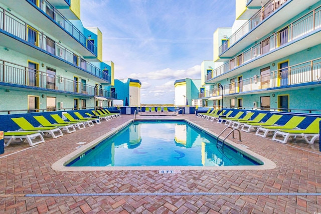 community pool with a residential view and a patio