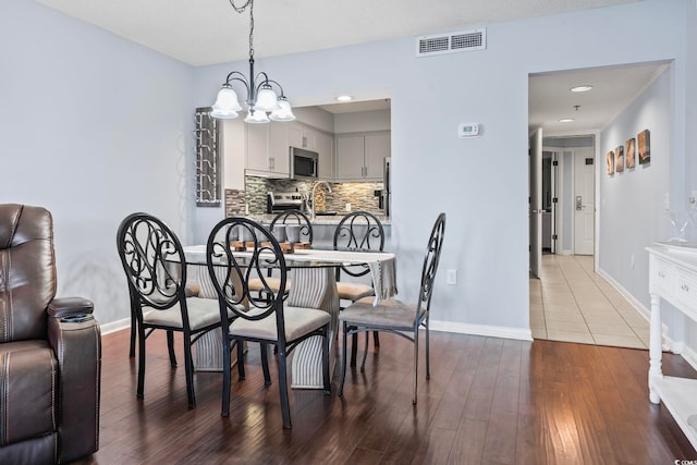 dining area with a chandelier, dark wood-style floors, baseboards, and recessed lighting