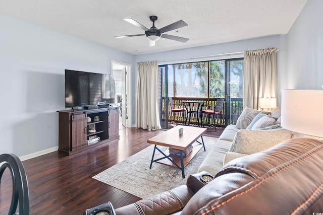 living room with baseboards, a ceiling fan, dark wood-style flooring, and a textured ceiling