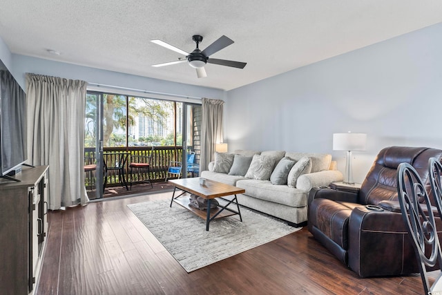 living area with ceiling fan, dark wood-style floors, and a textured ceiling