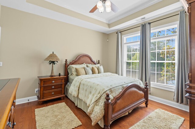 2213 Gazebo Ct, North Myrtle Beach, SC 29582 - bedroom featuring ornamental molding, baseboards, wood finished floors, a raised ceiling, and a ceiling fan
