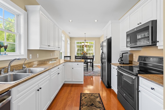 2213 Gazebo Ct, North Myrtle Beach, SC 29582 - kitchen featuring stainless steel appliances, a sink, a chandelier, light wood-style flooring, and white cabinets