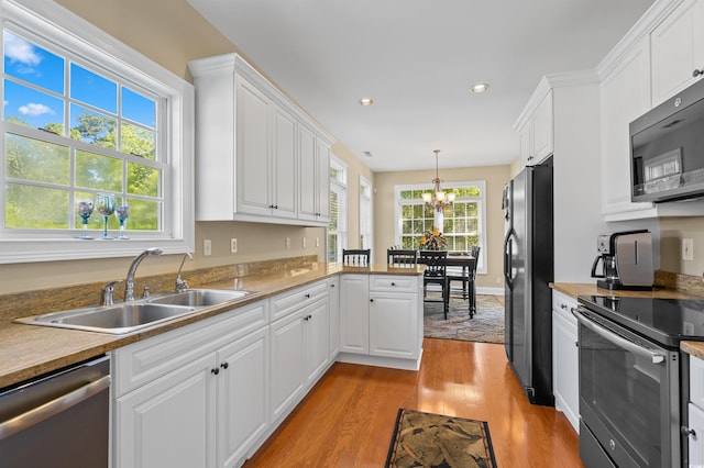 2213 Gazebo Ct, North Myrtle Beach, SC 29582 - kitchen with appliances with stainless steel finishes, a sink, light wood-style floors, a chandelier, and white cabinets