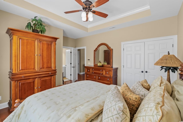 2213 Gazebo Ct, North Myrtle Beach, SC 29582 - bedroom featuring a closet, dark wood-type flooring, a tray ceiling, baseboards, and ceiling fan