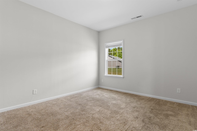 carpeted empty room featuring baseboards
