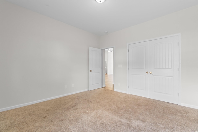 unfurnished bedroom with carpet floors, baseboards, and a closet