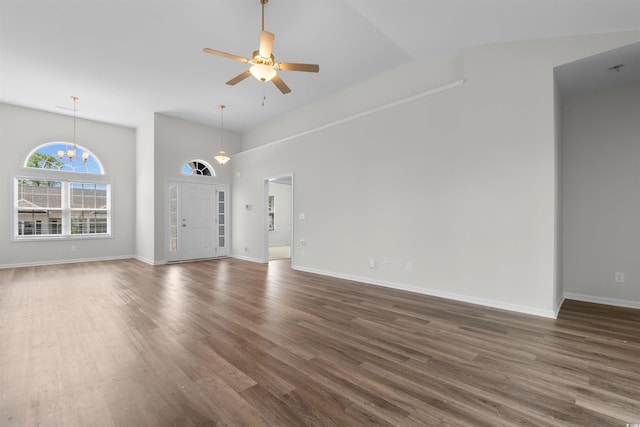 unfurnished living room with a ceiling fan, dark wood-type flooring, high vaulted ceiling, and baseboards