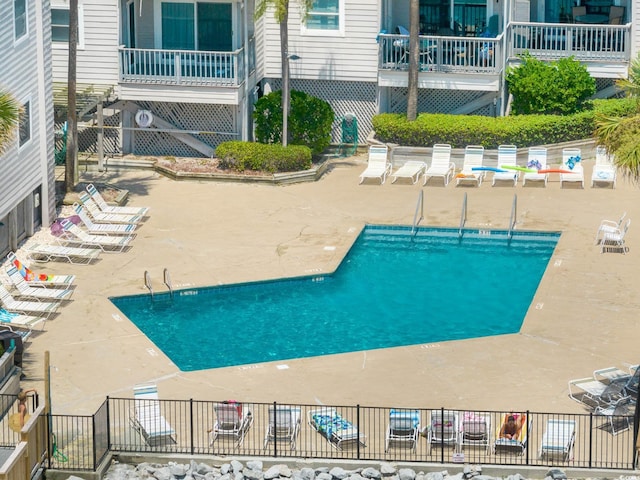 community pool featuring a patio and fence