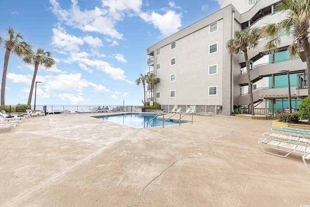 community pool featuring a patio and fence