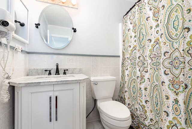 1310 N Waccamaw Dr Unit 211, Garden City Beach, SC 29576 - full bath featuring tile walls, toilet, vanity, and a wainscoted wall