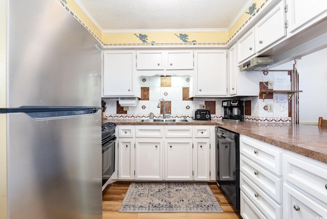 kitchen featuring black appliances, a sink, ornamental molding, white cabinets, and decorative backsplash