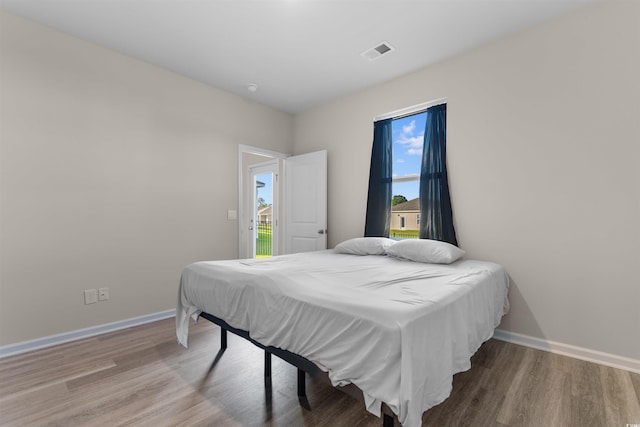 bedroom with wood finished floors and baseboards